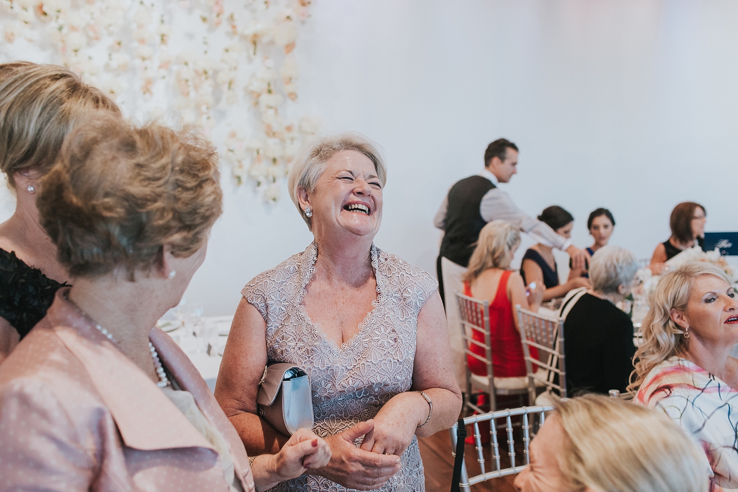 mother of the groom laughs with guests at the mca