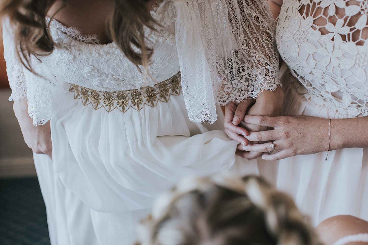 holding hands with her maid of honour during bridal prep
