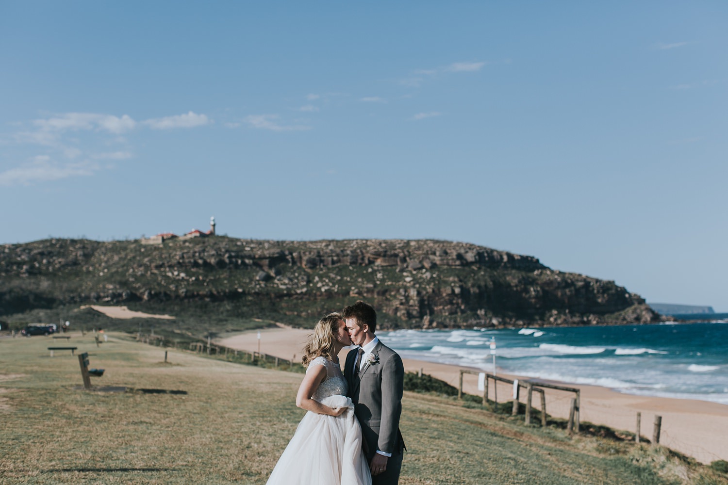 bride and groom with palm beach headland behind them
