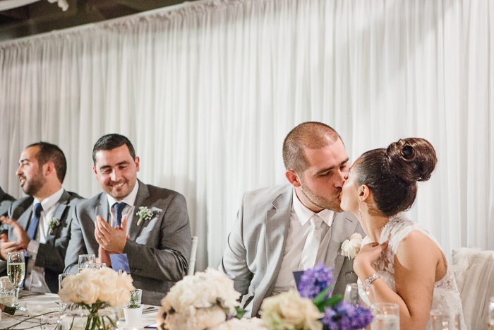 bride-groom-kiss-at-wedding-table