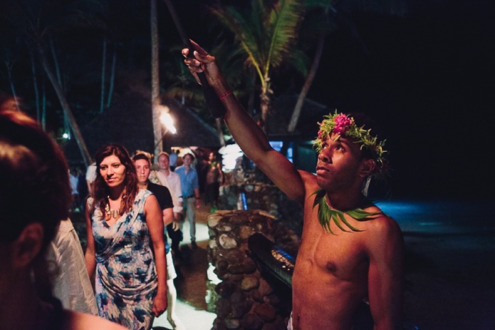 Fiji dancers hold fire sticks to farewell couple
