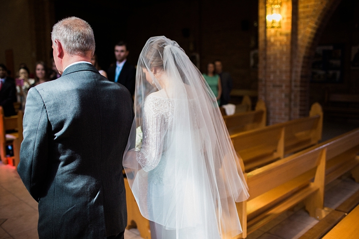 bride walking down the aisle in catholic ceremony