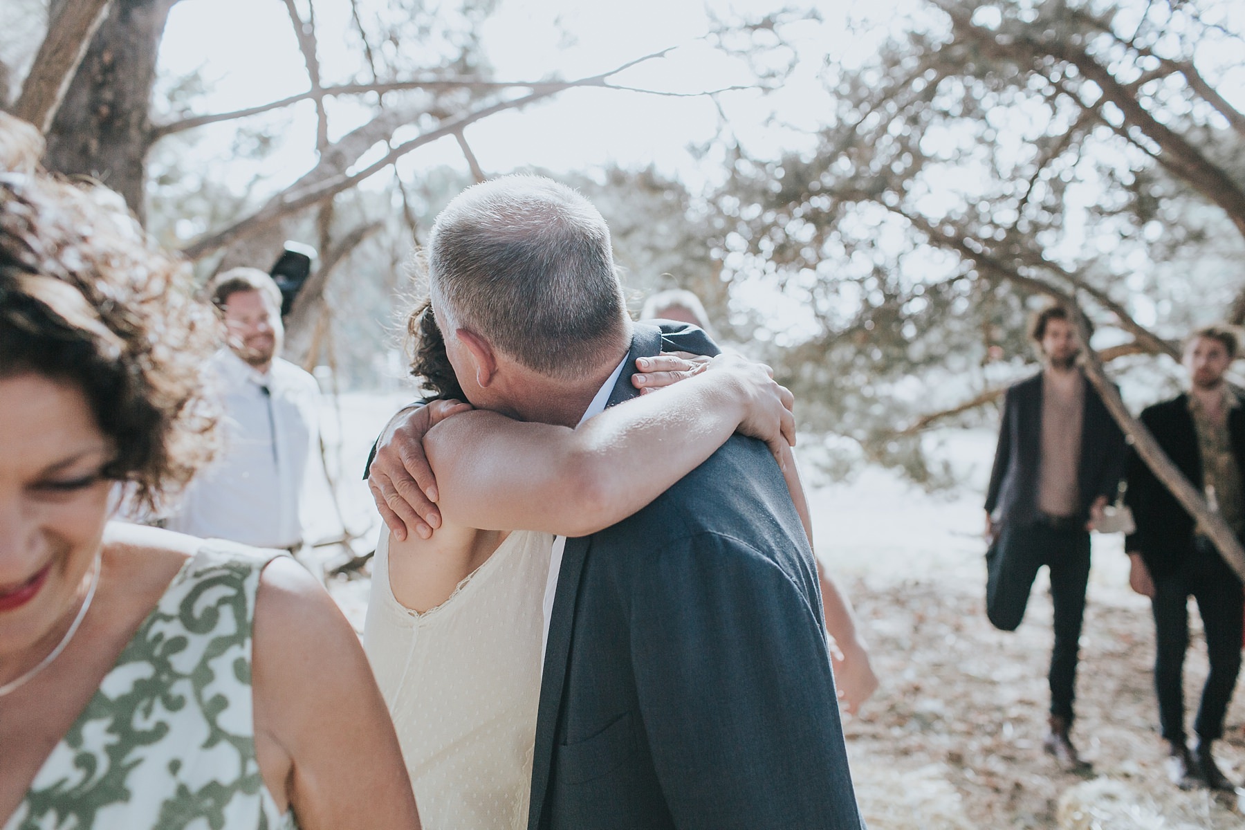 bride hugs her father during wedding ceremony