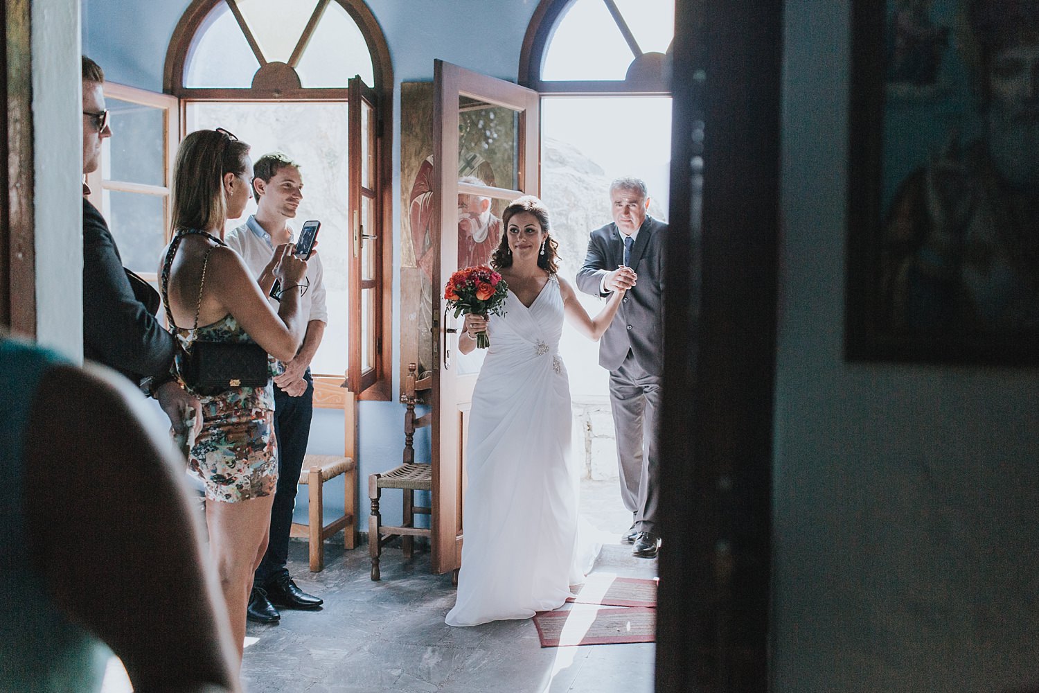 bride enters greek orthodox church for wedding