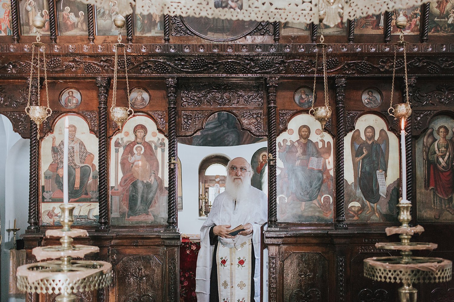 greek orthodox priest watches on from the sanctuary