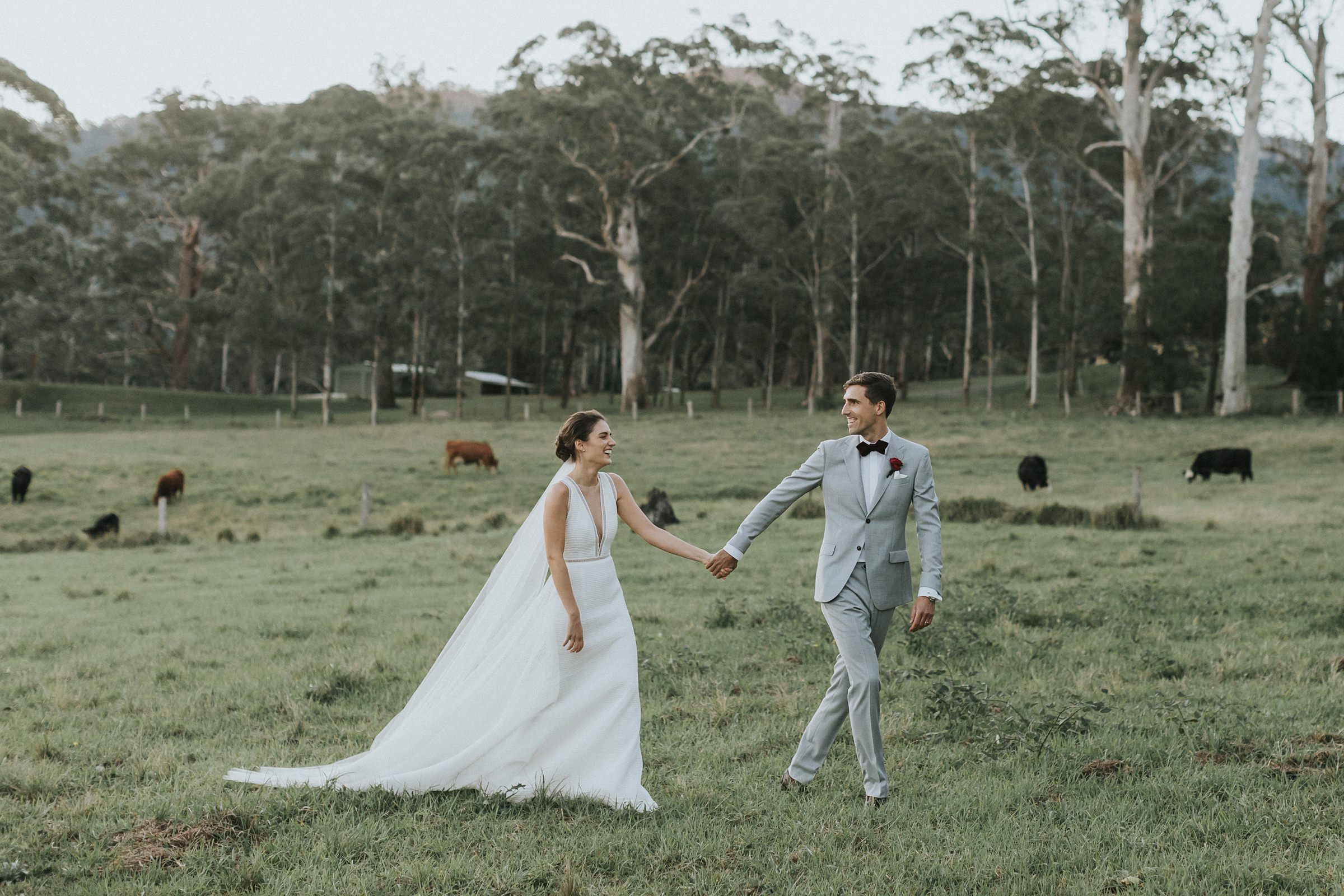 bride and groom go for a walk through the paddocks on their wedding day