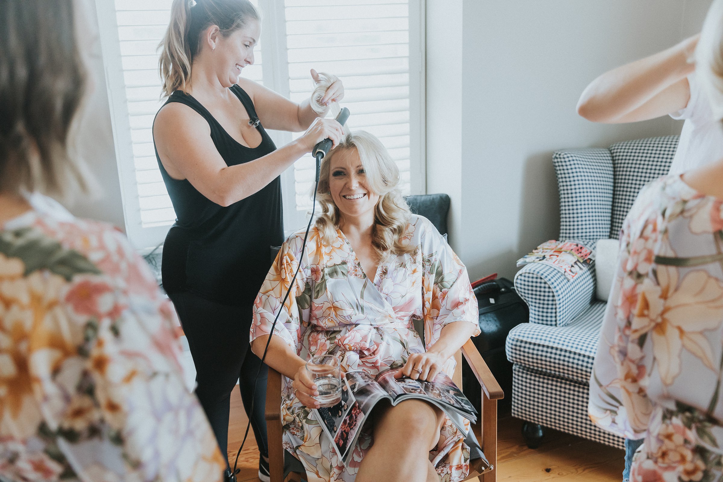 sister of the bride getting her hair done during wedding prep